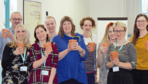Attendees stood with plants they potted during the Growing Greens Spaces workshop