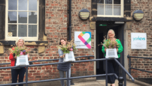 Members of York CVS staff team stand outside the Priory Street Centre with donated flowers