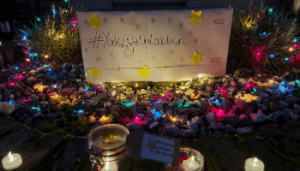 Candles and a string of small coloured lights with a sign that says York light up lockdown