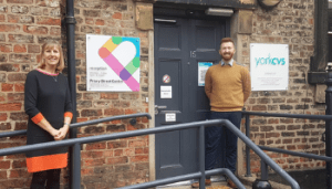 Bev Frain and Drew Richardson stood outside the main doors to teh Priory Street Centre