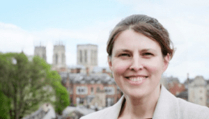 Rachael Maskell MP: white female with brown hair stood on York walls with York Minister in the background.