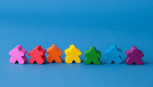 Wooden people figures in the different colours of the rainbow to symbolise the Gay Pride flag