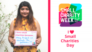 Asian female with long brown hair holding an a4 piece of paper which reads: I love small charities because... they helped us through the pandemic!!! In the background is a plain wall and a small tree. Small Charity Week logo 14-21 June 2021. I heart small charities day.