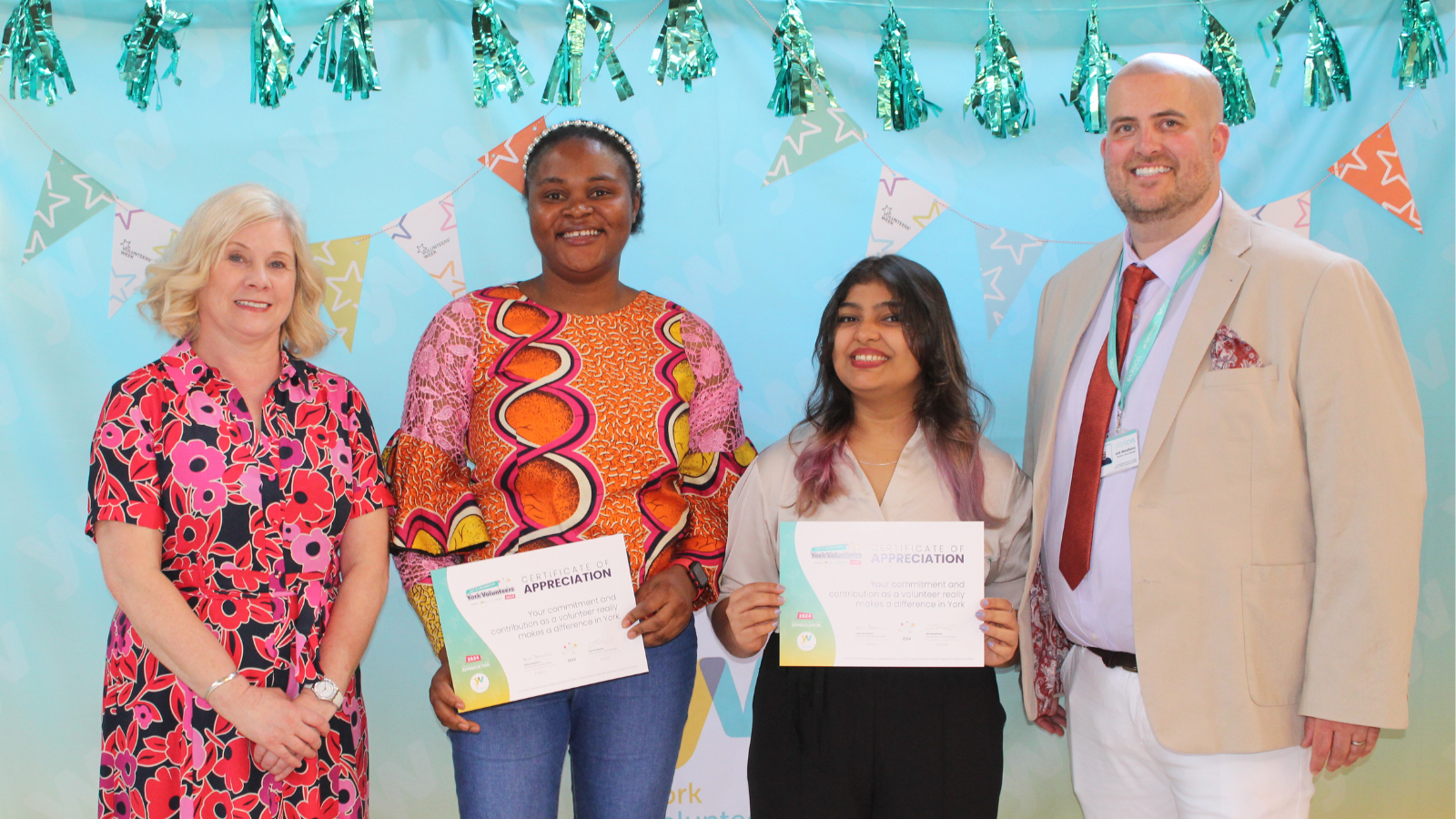 Let's Celebrate! York Volunteers - Dementia Forward Image shows four people at the Lets Celebrate York Volunteers. Two of them are holding certificates of gratitude to their volunteering roles.