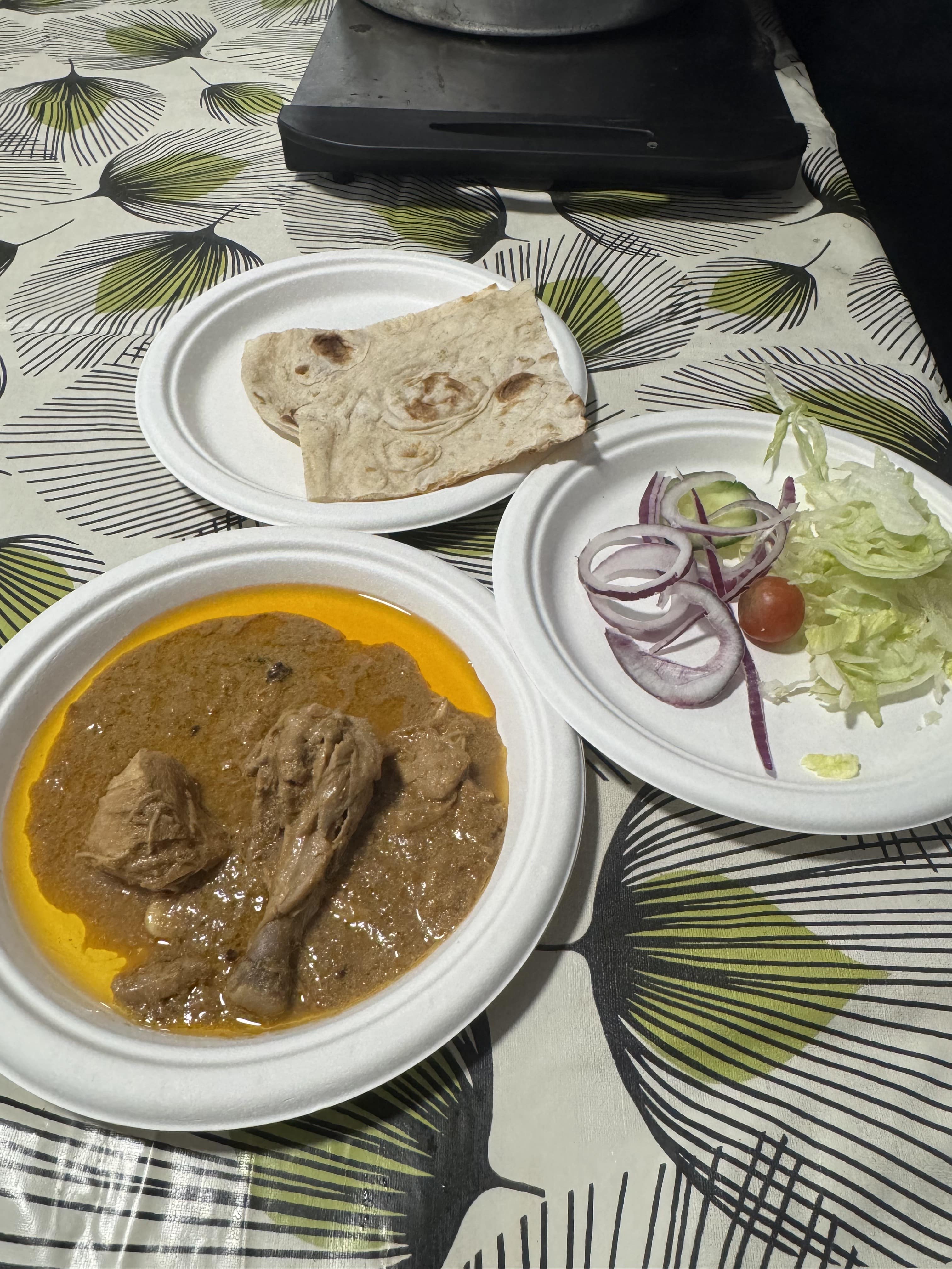 IMG_0121-min Three plates of food are shown, one is chicken korma, another a plate of salad and the third is a chapati.