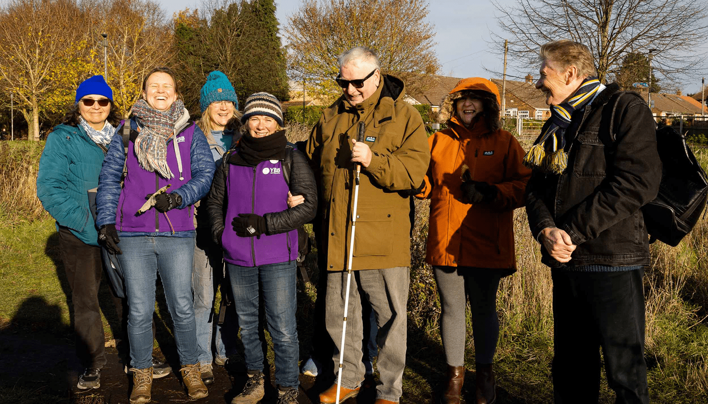 York Bike Belles Image shows a group of people wrapped up in coats and scarves on a sunny winter day on a walk in nature.