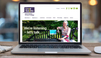 Laptop screen showing the Lived Insights website homepage with a banner reading 'We're listening – let's talk' and a person sitting on a bench in a garden setting.