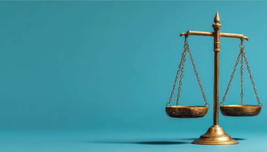 Antique brass balance scale with two empty pans against a solid teal background, symbolising justice and fairness.