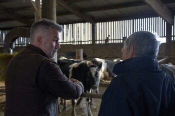 Image of David Skaith stood next to a farmer in a cow shed