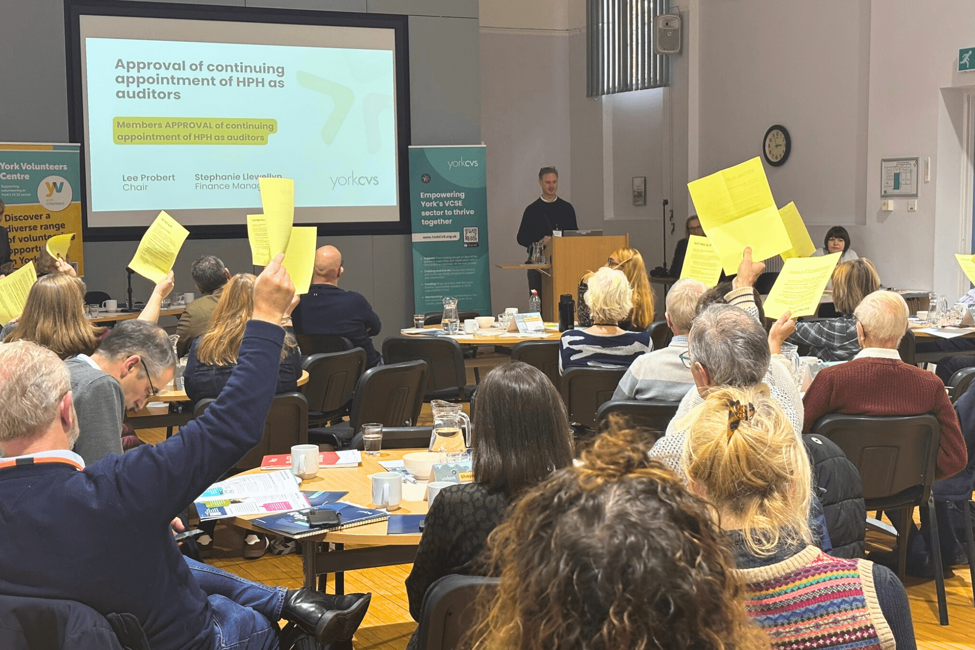 Image of people waving yellow pages to vote 