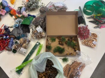 Image of a table with foliage and festive decorations during a wreath making class.