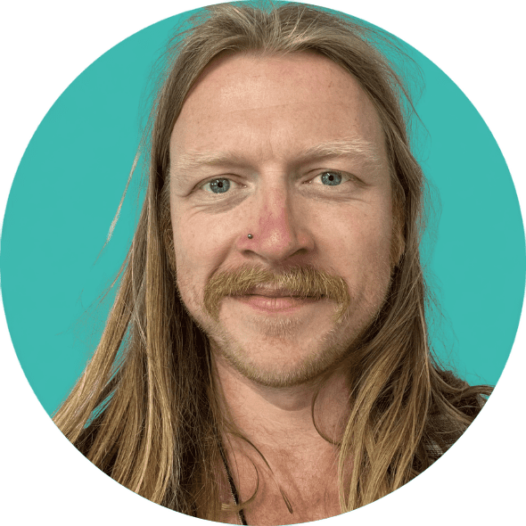 A headshot picture of Ben Hutchinson, our co-production champion. His head is framed in a turquoise circle. He is smiling towards the camera. He is white with long dark blonde hair which is worn down. He has a dark blonde moustache and a small stud in his right nostril